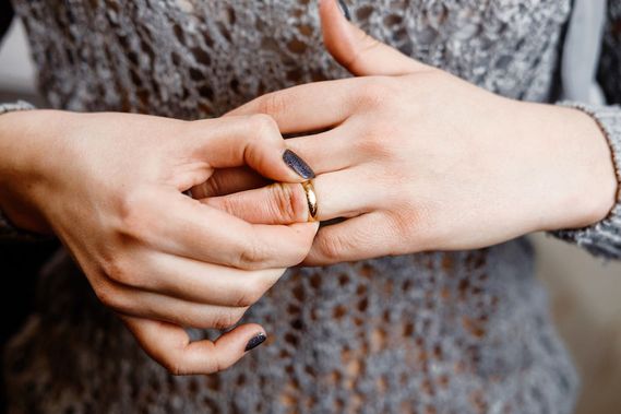 geschiedene Frau nimmt Ehering vom Finger